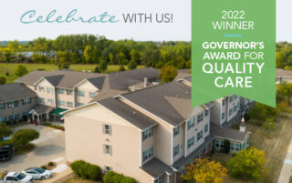 Drone photo of Newton Village Assisted Living with green banner announcing Governor's Award for Quality Care
