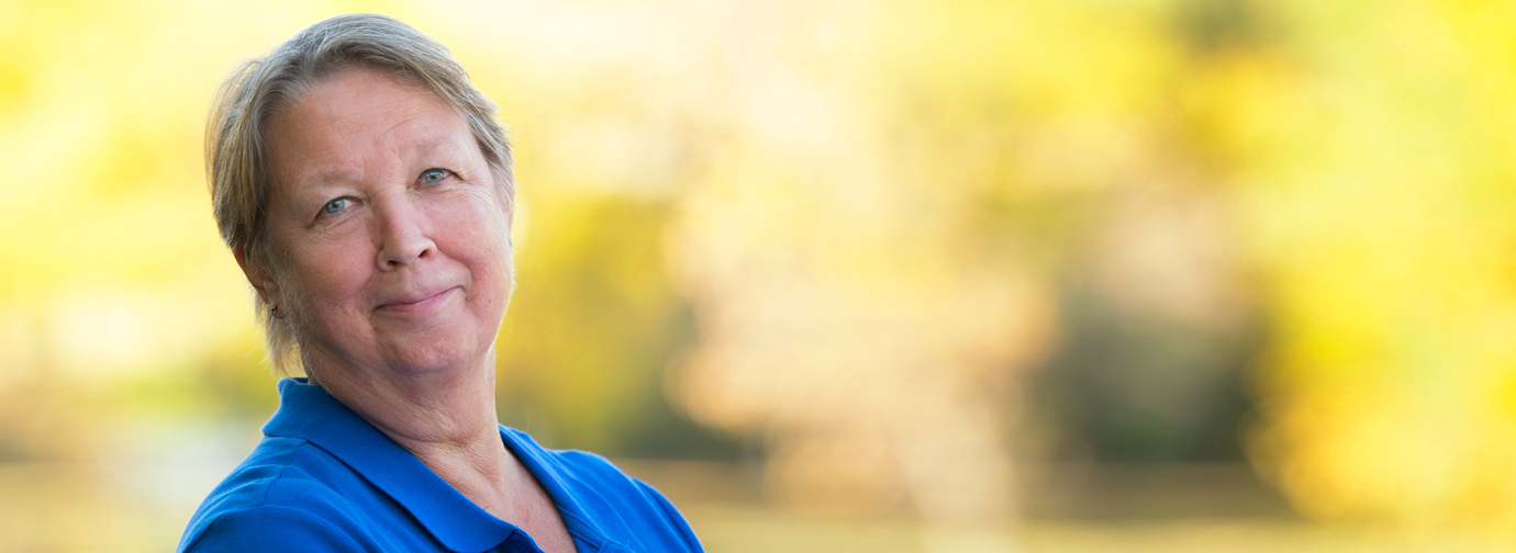 Woman in blue shirt smiling at the camera