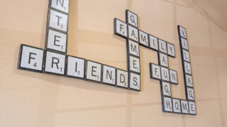 Scrabble-style wall art highlighting community values like family, friends, and home in a senior living community in Newton, IA.