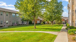 Courtyard with green space and walking paths at Newton Village senior living community in Newton, IA.