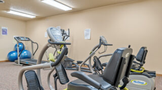 Fitness room with cardio and strength equipment in a senior living community in Newton, IA.
