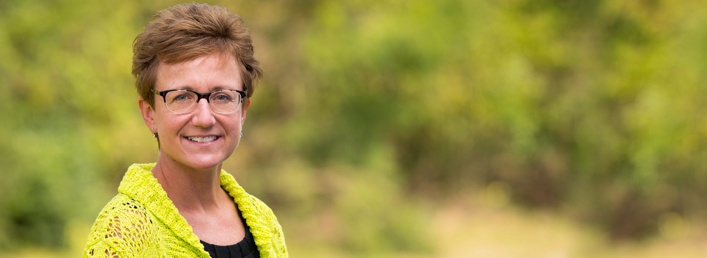 Employee portrait outdoors with greenery in the background, representing staff like at Newton Village