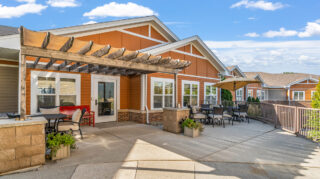 Outdoor patio with seating and shaded areas in a senior living community in Newton, IA.